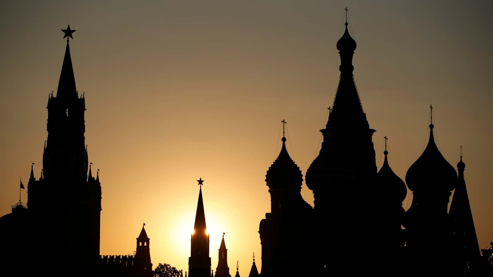 The sun sets behind the Kremlin’s Spasskaya Tower and St. Basil’s Cathedral during the soccer World Cup in Moscow, Russia, June 18, 2018. As well…