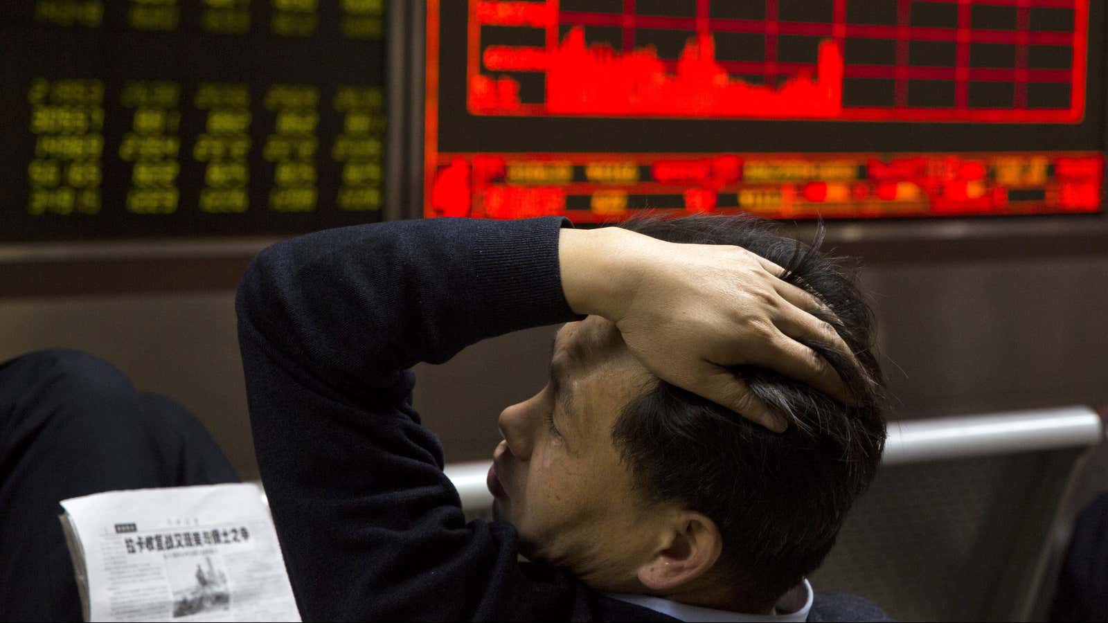 A Chinese man reacts near a board showing the Shanghai Stock Exchange Composite Index at a brokerage in Beijing, China, Wednesday, Nov. 9, 2016. The…