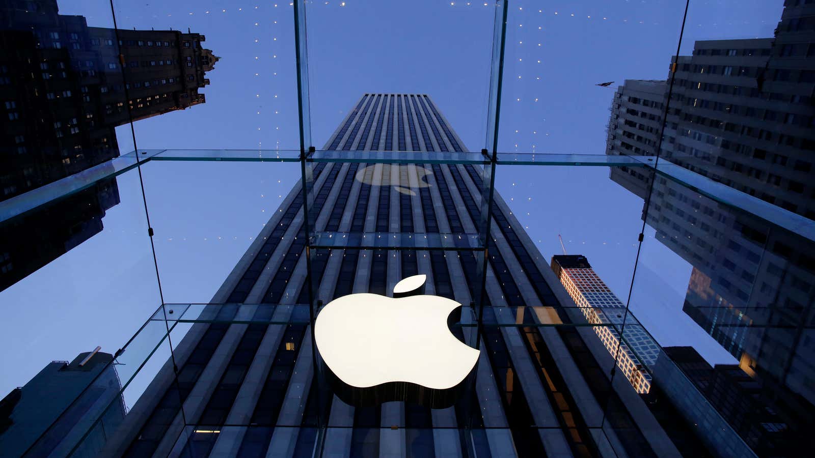 FILE – In this Sept. 5, 2014, file photo, the Apple logo hangs in the glass box entrance to the company’s Fifth Avenue store in…