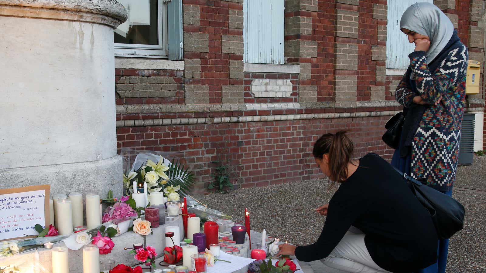 Women pay their respects to Father Jacques Hamel in Rouen, France.