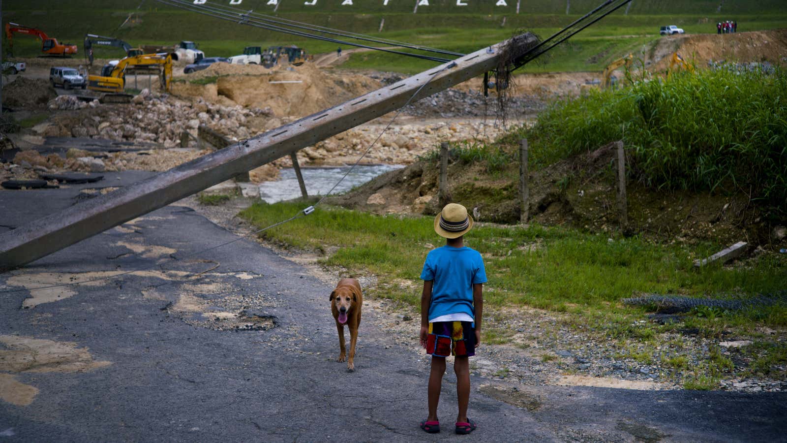 A boy watches the repairs to the Guajataca Dam, which cracked during the passage of Hurricane Maria in Quebradillas on Oct. 17.