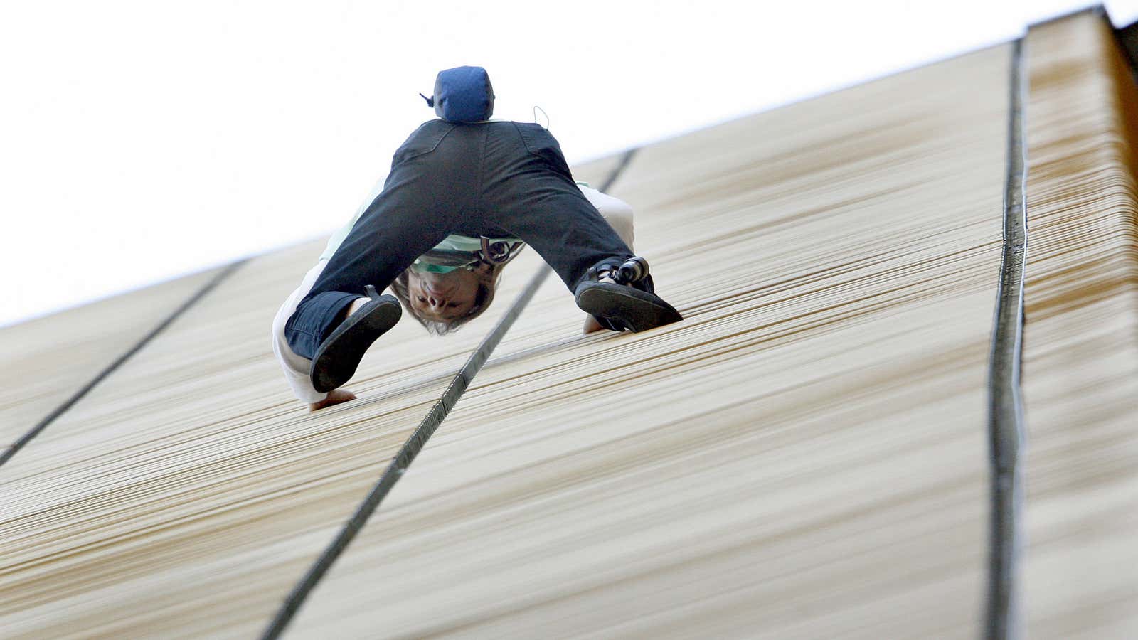 A man climbs an office tower in Berlin. Some investors feel their struggle to buy distressed assets is just as hard.