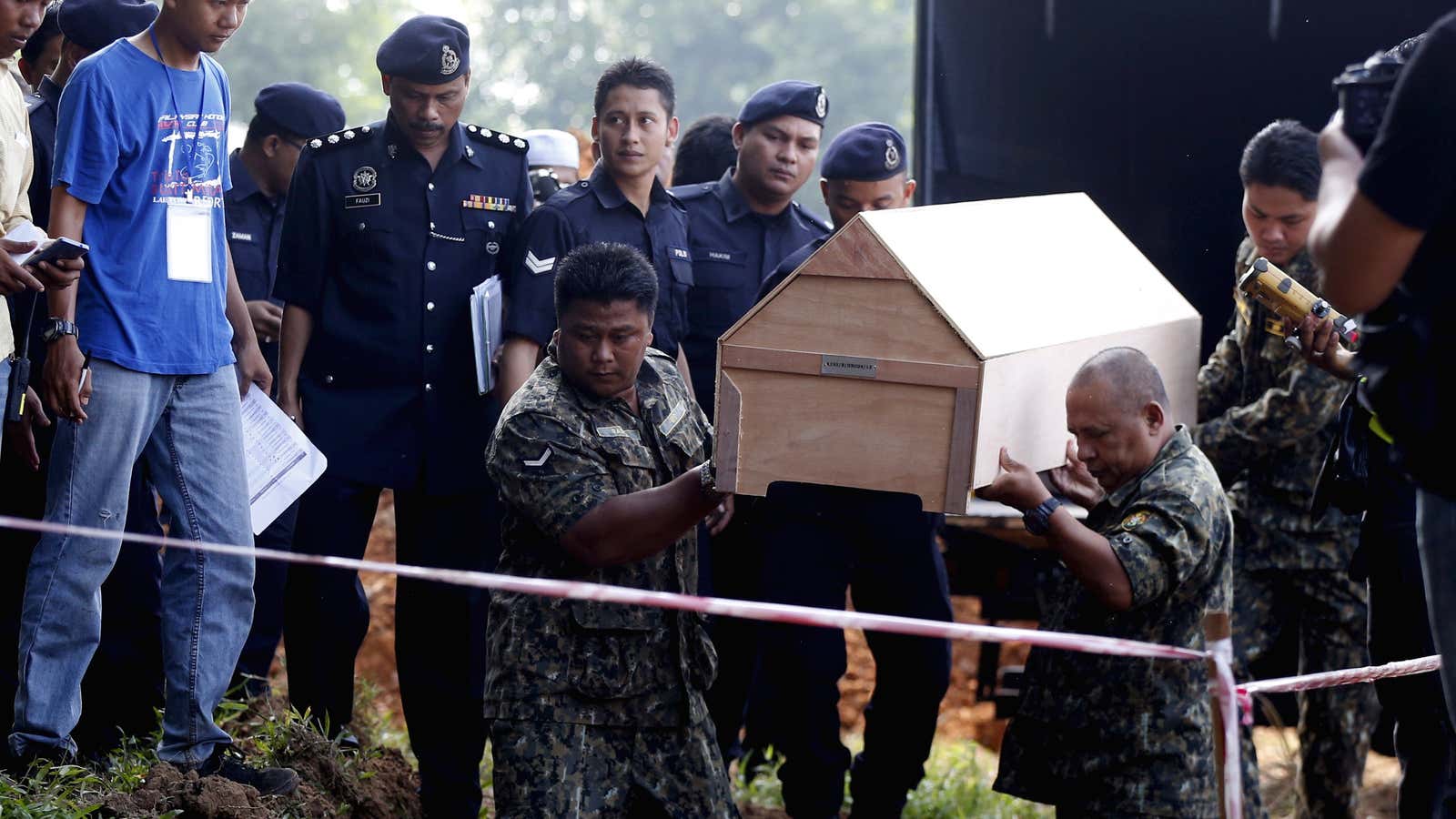Malaysian police carry a coffin with unidentified remains of Rohingya people found at a traffickers camp on the border with Thailand.