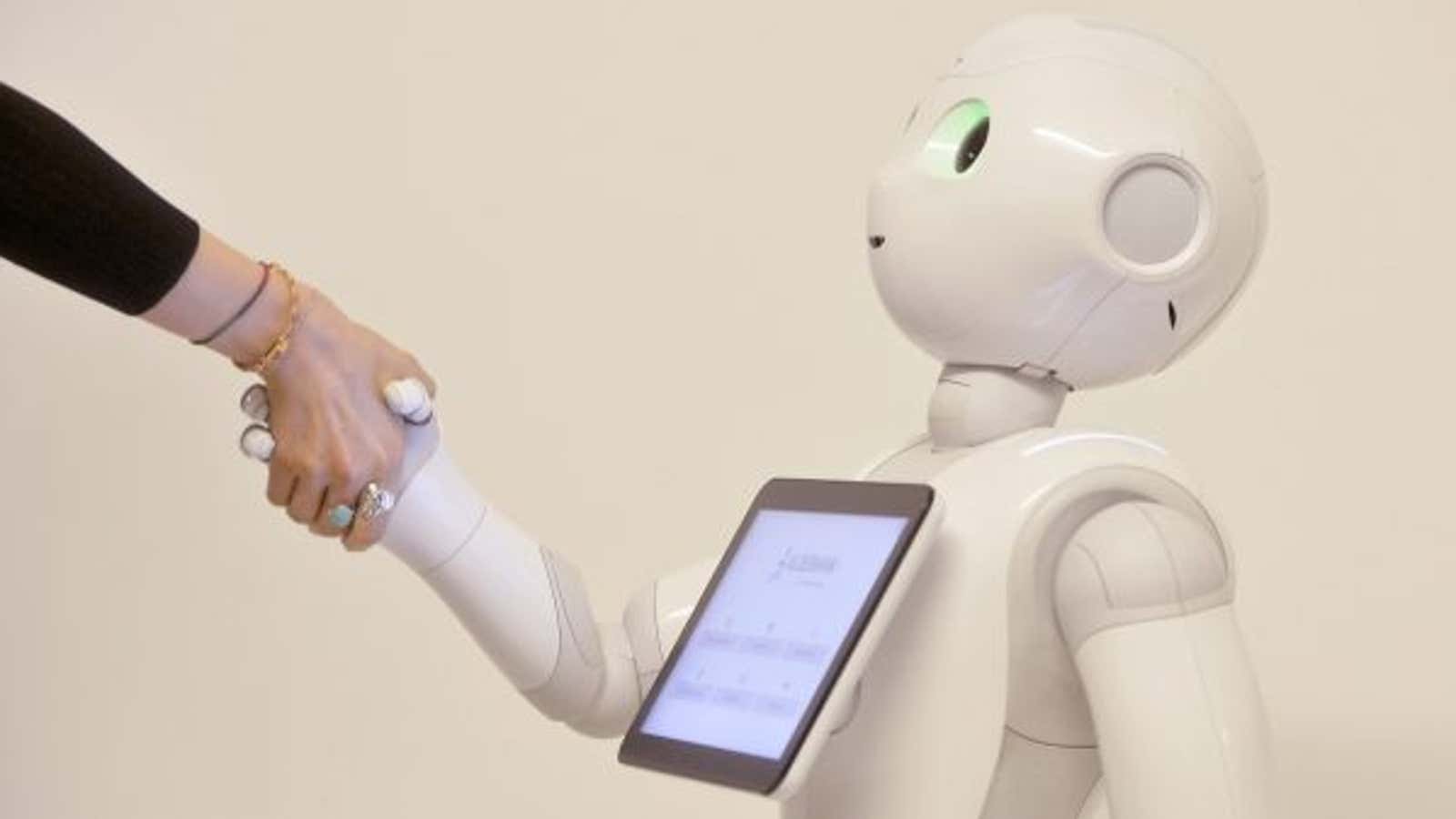 A humanoid robot shakes a human’s hand