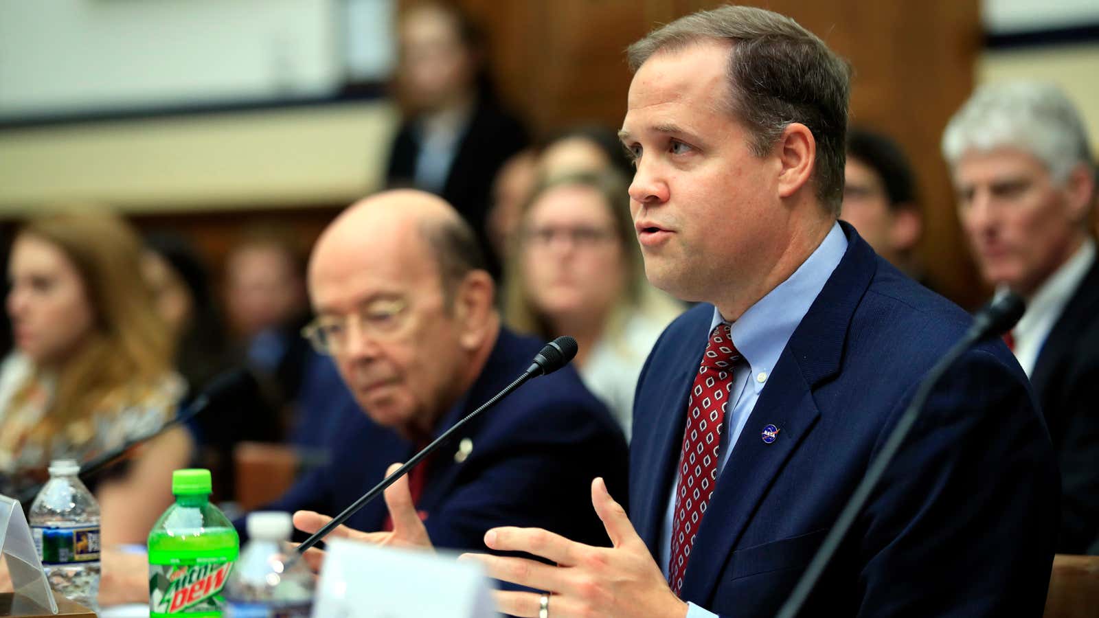 NASA Administrator Jim Bridenstine with Commerce Secretary Wilbur Ross, left, testifies before a House Committee on Science, Space, and Technology Space Subcommittee and House Armed…