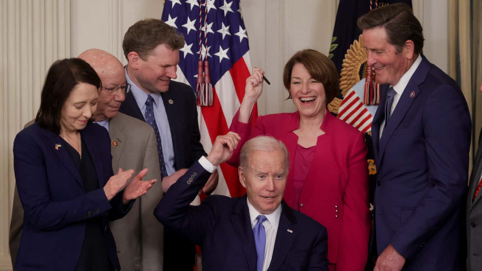US President Joe Biden and lawmakers celebrate the passage of the Ocean Shipping Reform Act.