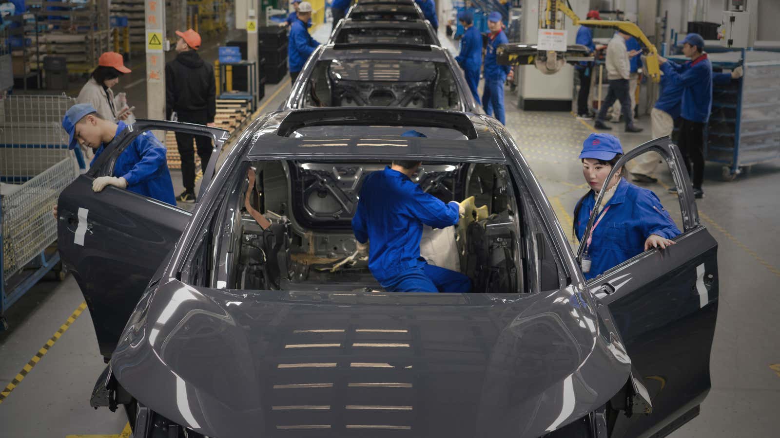 Workers assemble battery-powered automobiles with the help of automated and semi-automated processes at a BYD factory in Shenzhen in southern China.