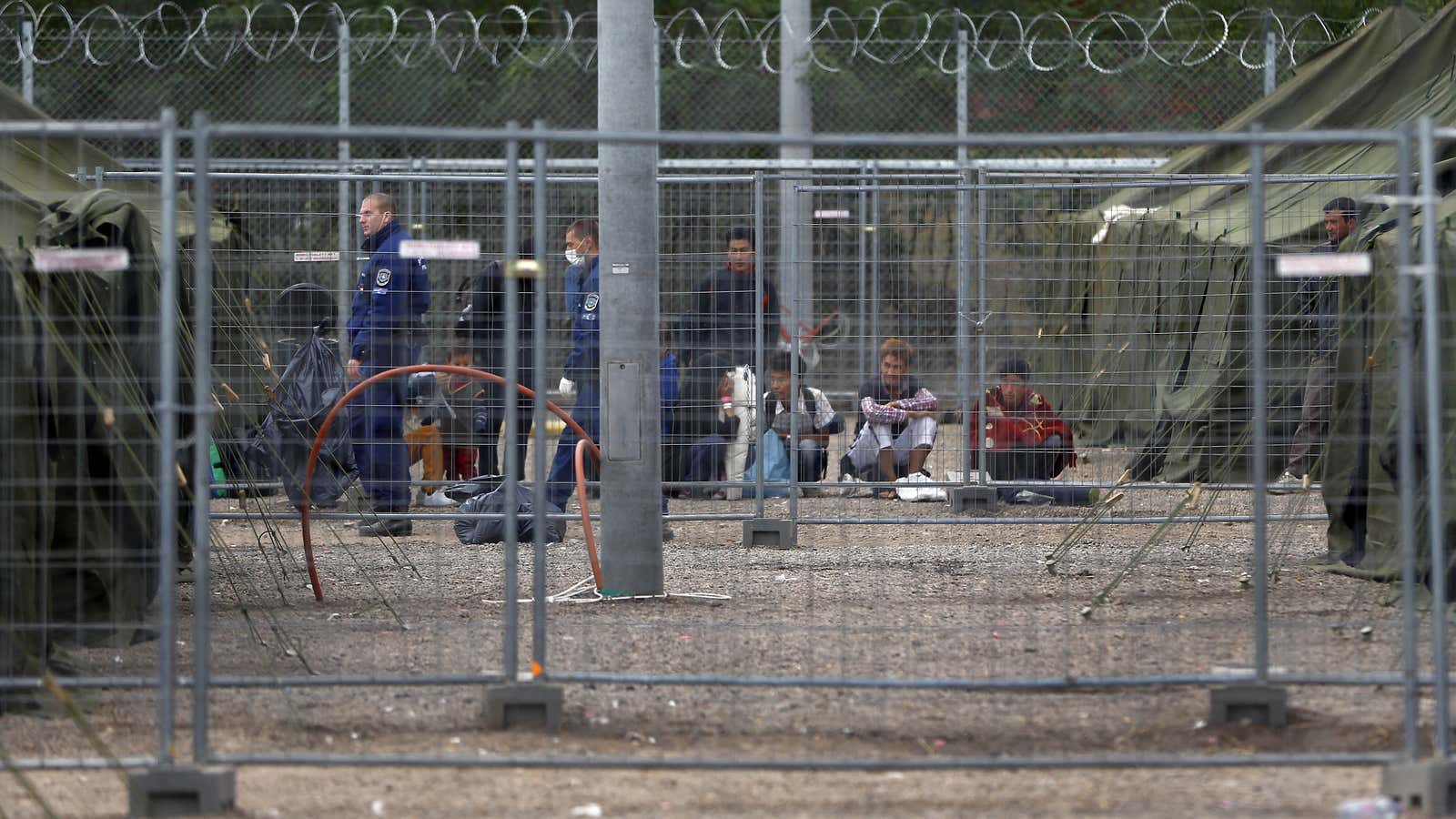 Video: Hungarian police treat refugees “like animals,” caging them and throwing food