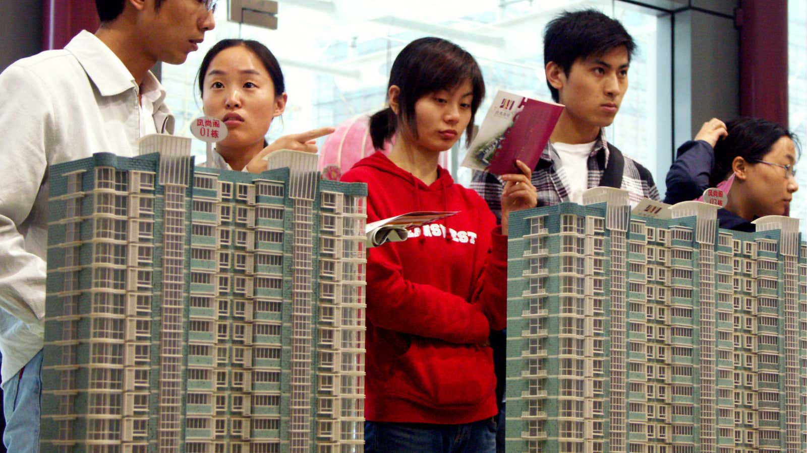 Chinese visitors look at model residential apartment buildings at a house fair in Nanjing city, east Chinas Jiangsu province, 8 April 2008. Chinese government on…