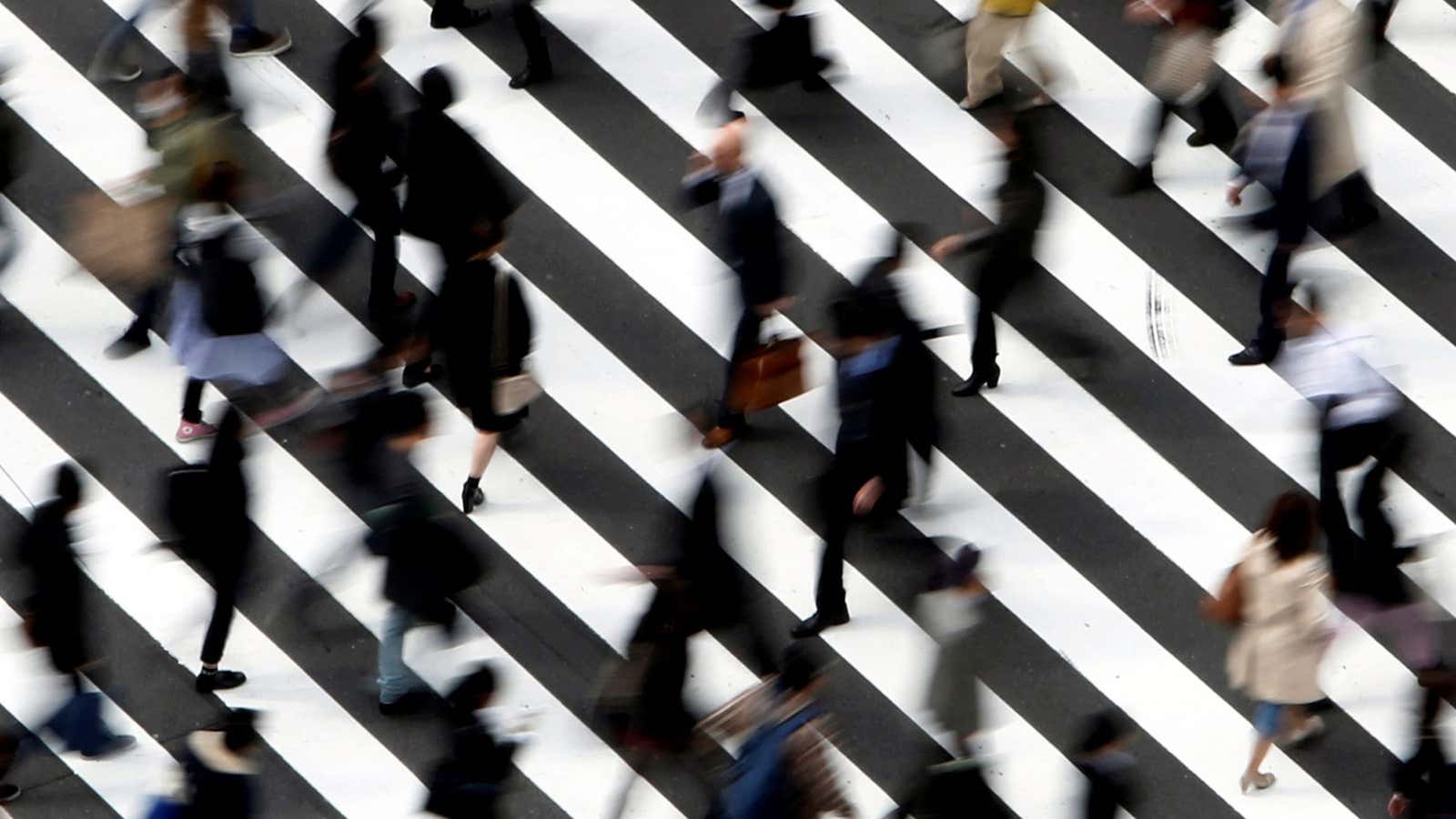 People cross a street in Tokyo March 18, 2015.
