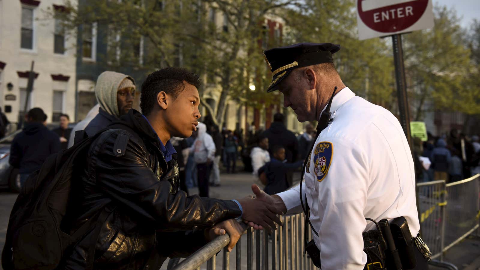 Ninth-grader Tremaine Holmes shakes hands with Captain Erik Pecha in front of the Baltimore Police Department.