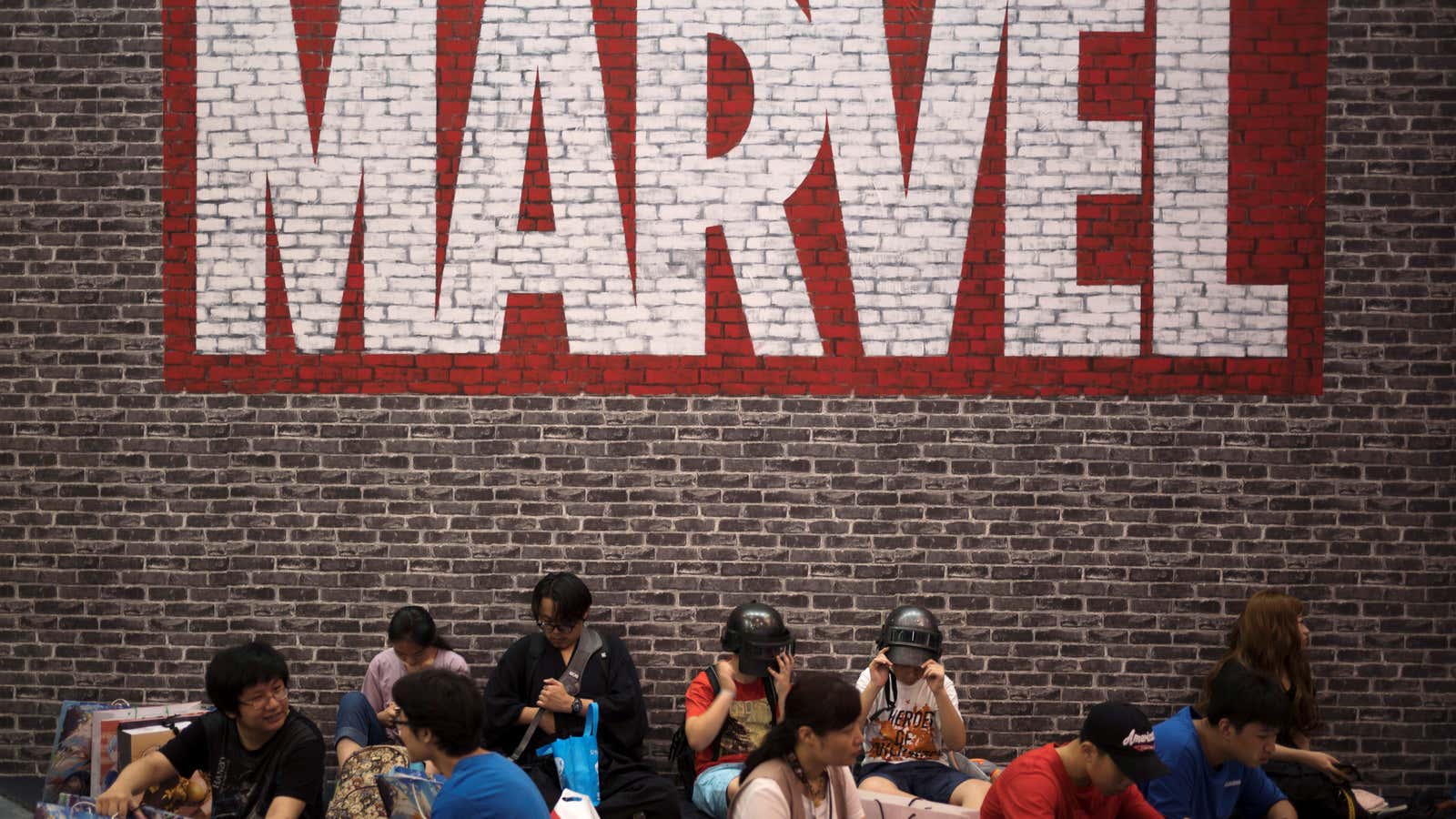 Visitors sit under a Marvel sign at the China International Cartoon and Game (CCG) Expo in Shanghai, China July 5, 2018. Picture taken July 5,…