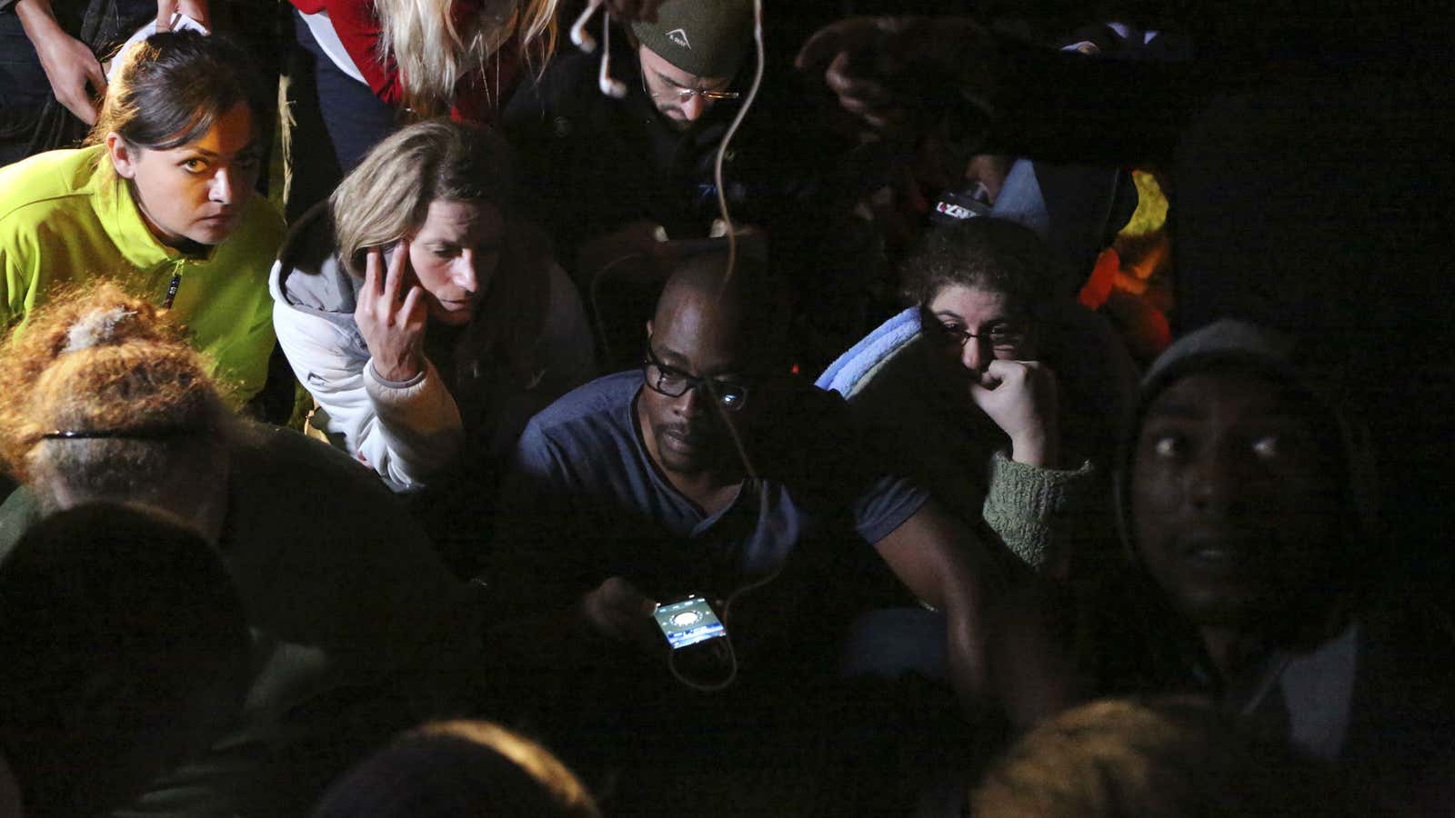 People in Johannesburg listen to a radio as president Jacob Zuma announces the death of Nelson Mandela.