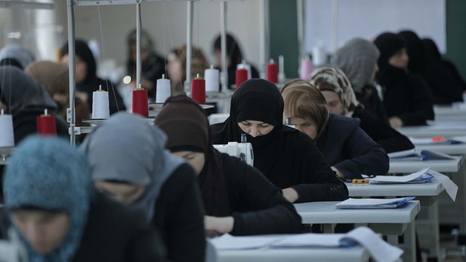 Syrian women practice sewing at a Turkish refugee camp.
