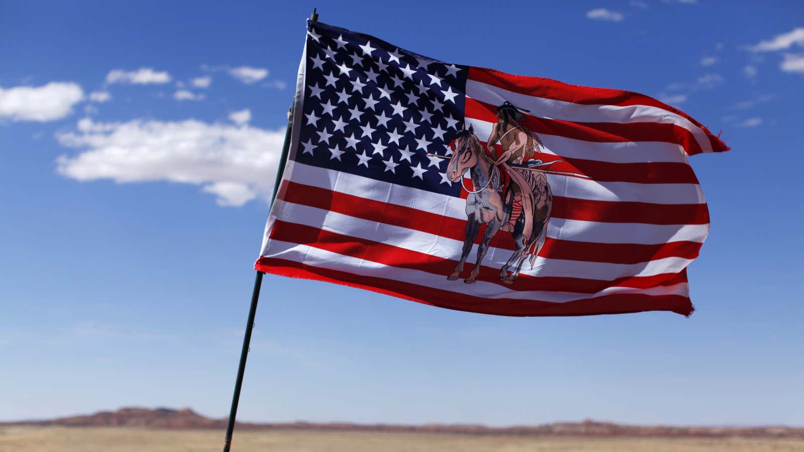 An embroidered American flag flies next to a jewelry stand on a Navajo reservation in Arizona.