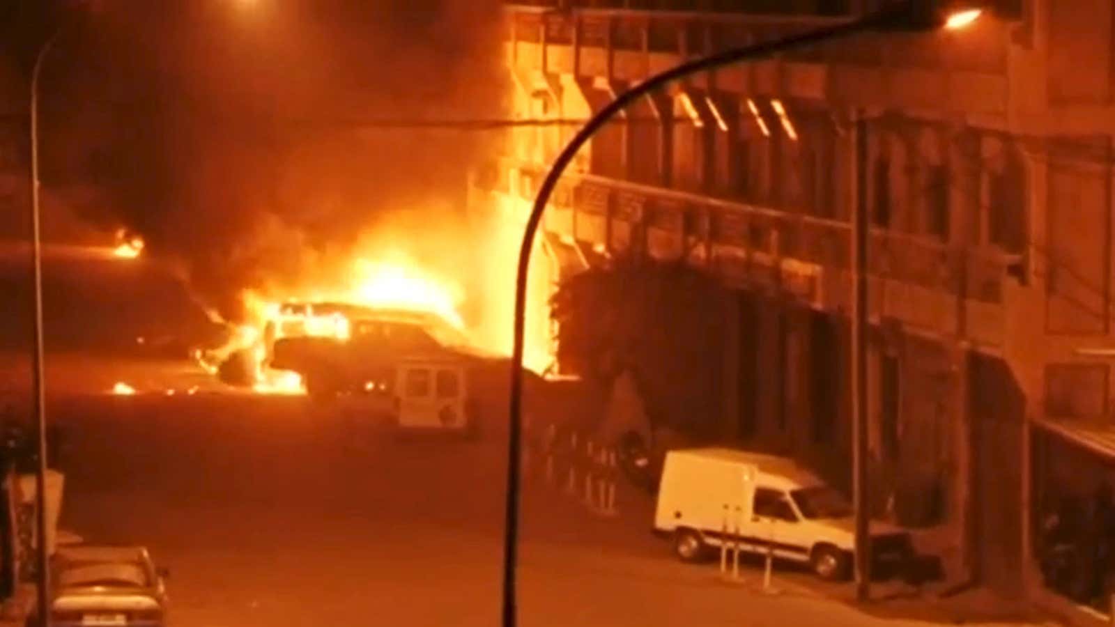 A view shows vehicles on fire outside Splendid Hotel in Ouagadougou,