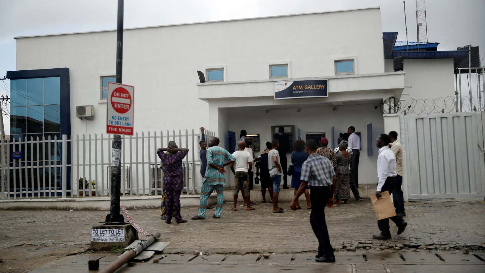 People queue to use an ATM at a bank in Lagos