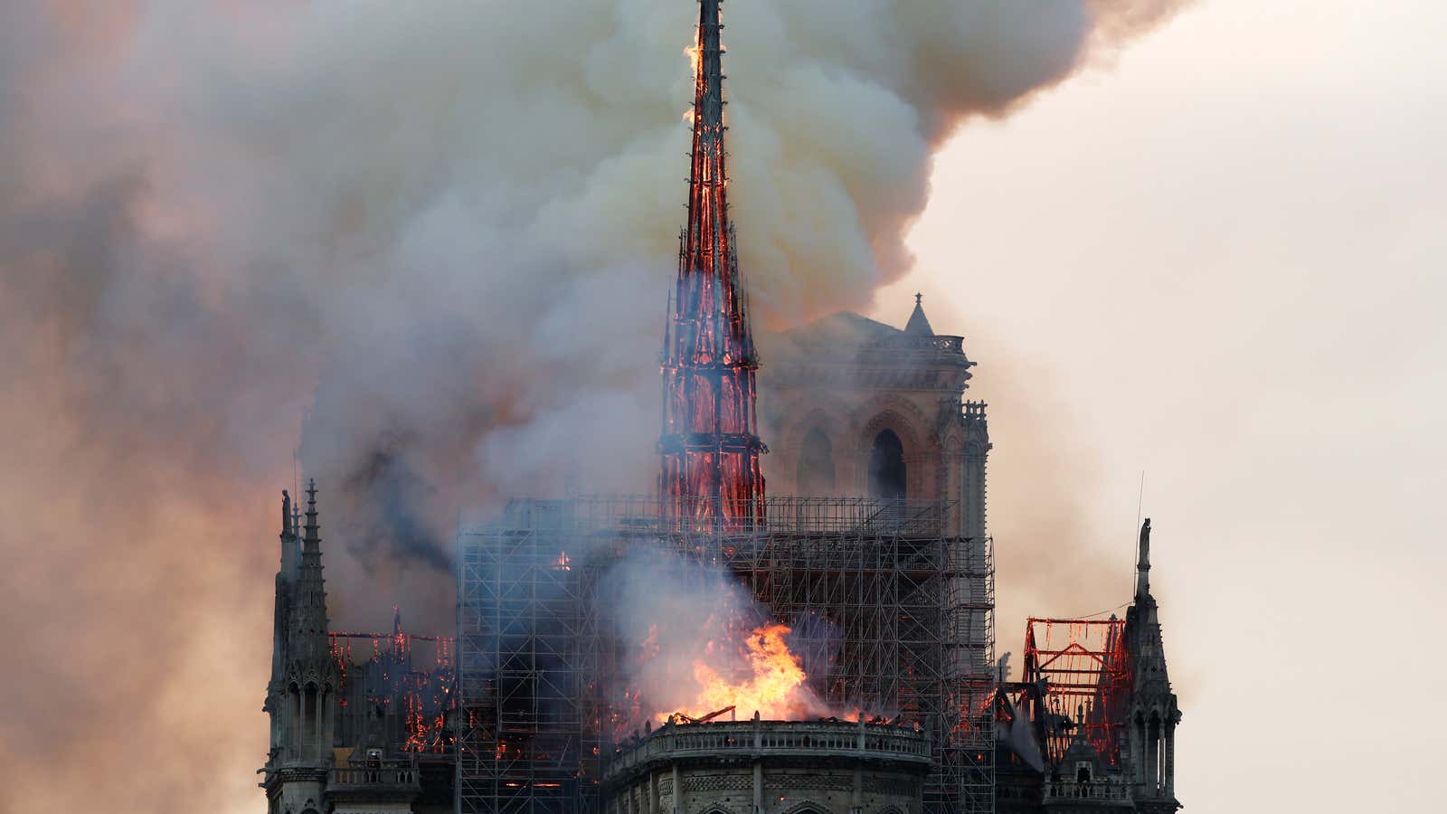 Smoke billows as fire engulfs the spire of Notre Dame cathedral.