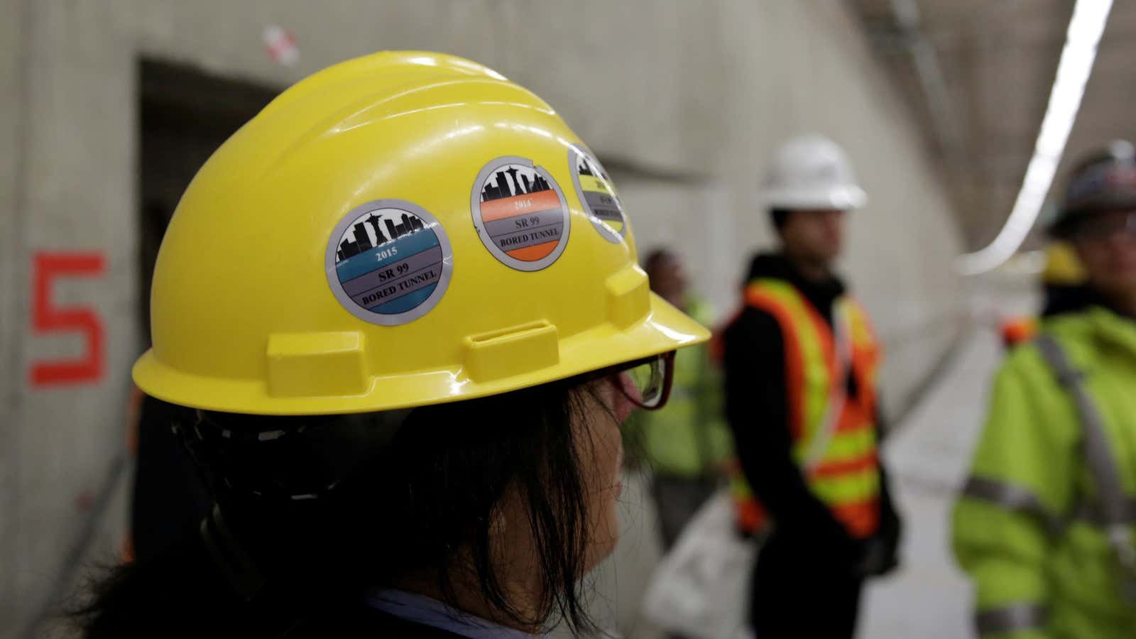 Stickers are pictured on a hard hat, during a media tour of the double deck State Route 99 highway tunnel, under construction in Seattle, Washington,…