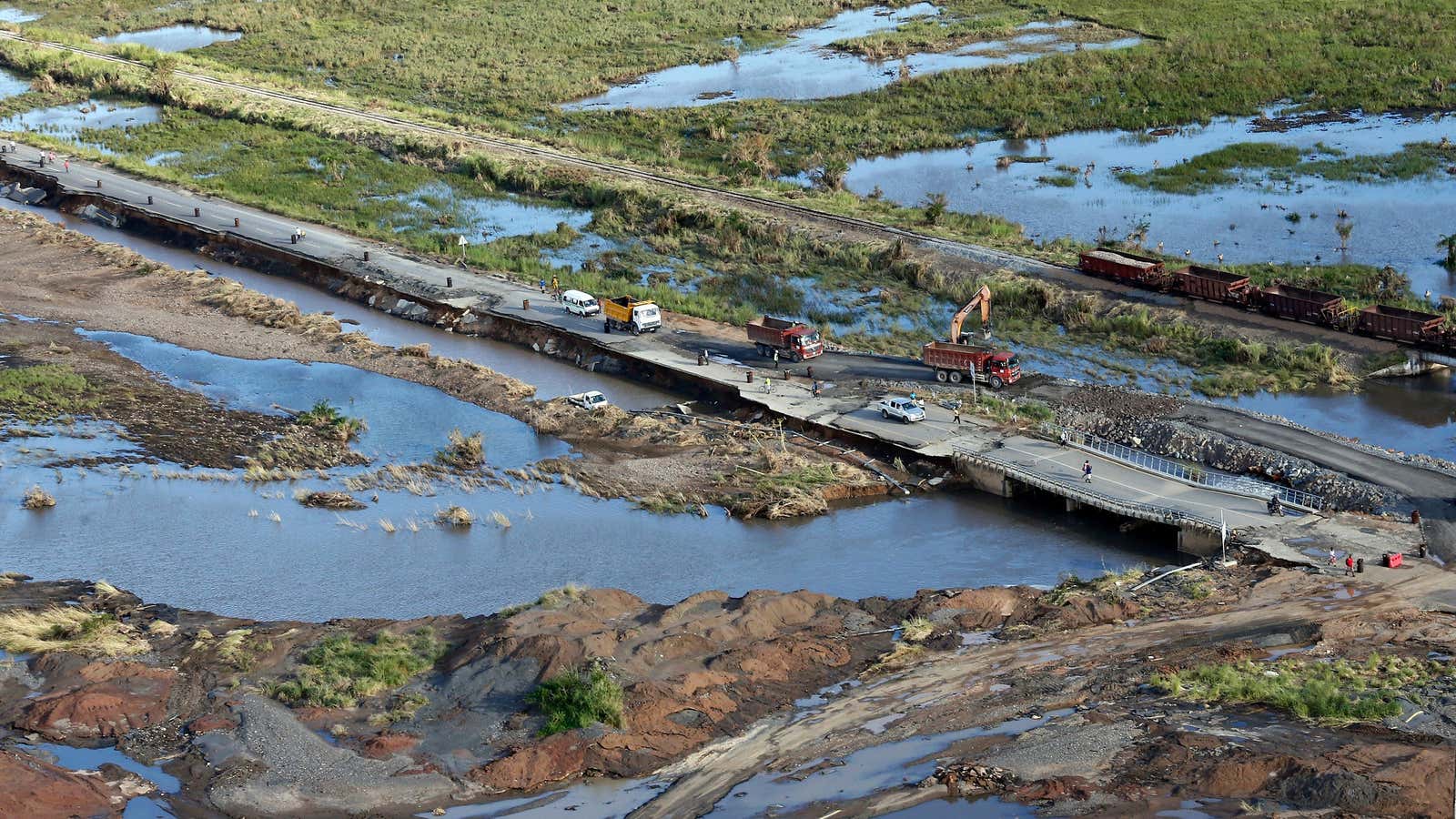 An aerial photo shows local residents walk on a damaged road following the devastating Tropical Cyclone Idai in Beira, Mozambique,