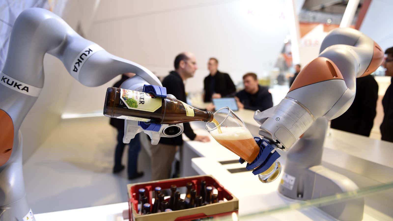 Robots in the Kuka stand pour a beer into a glass at the Hannover Messe industrial trade fair in Hanover, Germany.