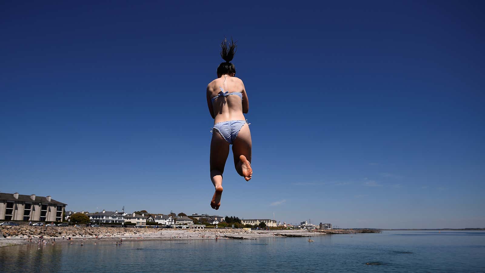 A woman jumps from a diving board into the sea on Salthill beach during sunny weather in Galway, Ireland June 26, 2018.