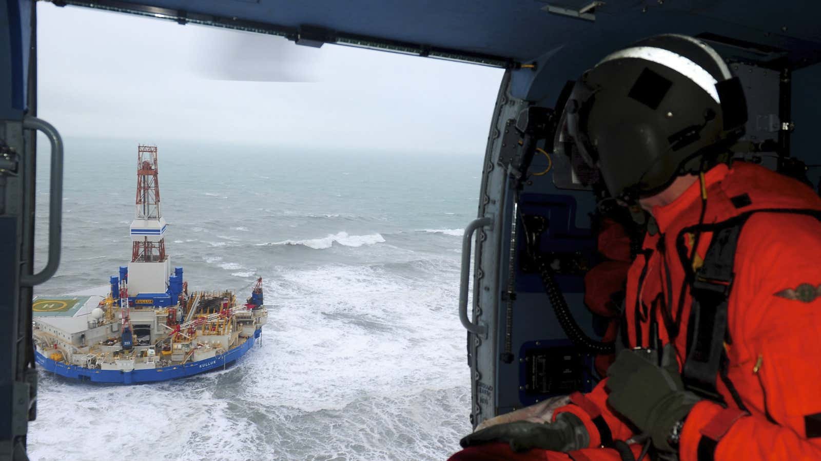 A rescue helicopter approaches the Kulluk rig, owned by Noble and leased by Shell, that ran aground in the Arctic.