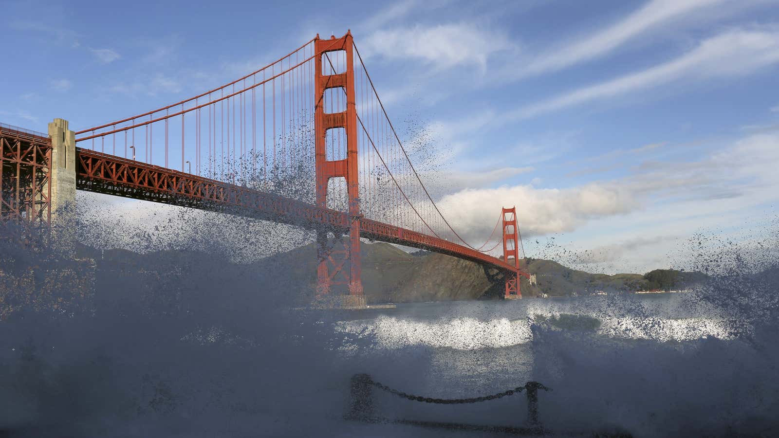 Waves crash against a sea wall in San Francisco Bay beneath the Golden Gate Bridge in San Francisco.