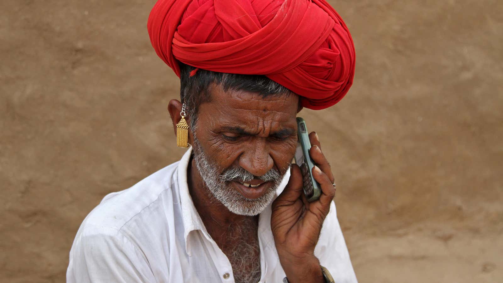 A man talks on his mobile phone in the village of Devmali in the desert state of Rajasthan, India June 14, 2016.