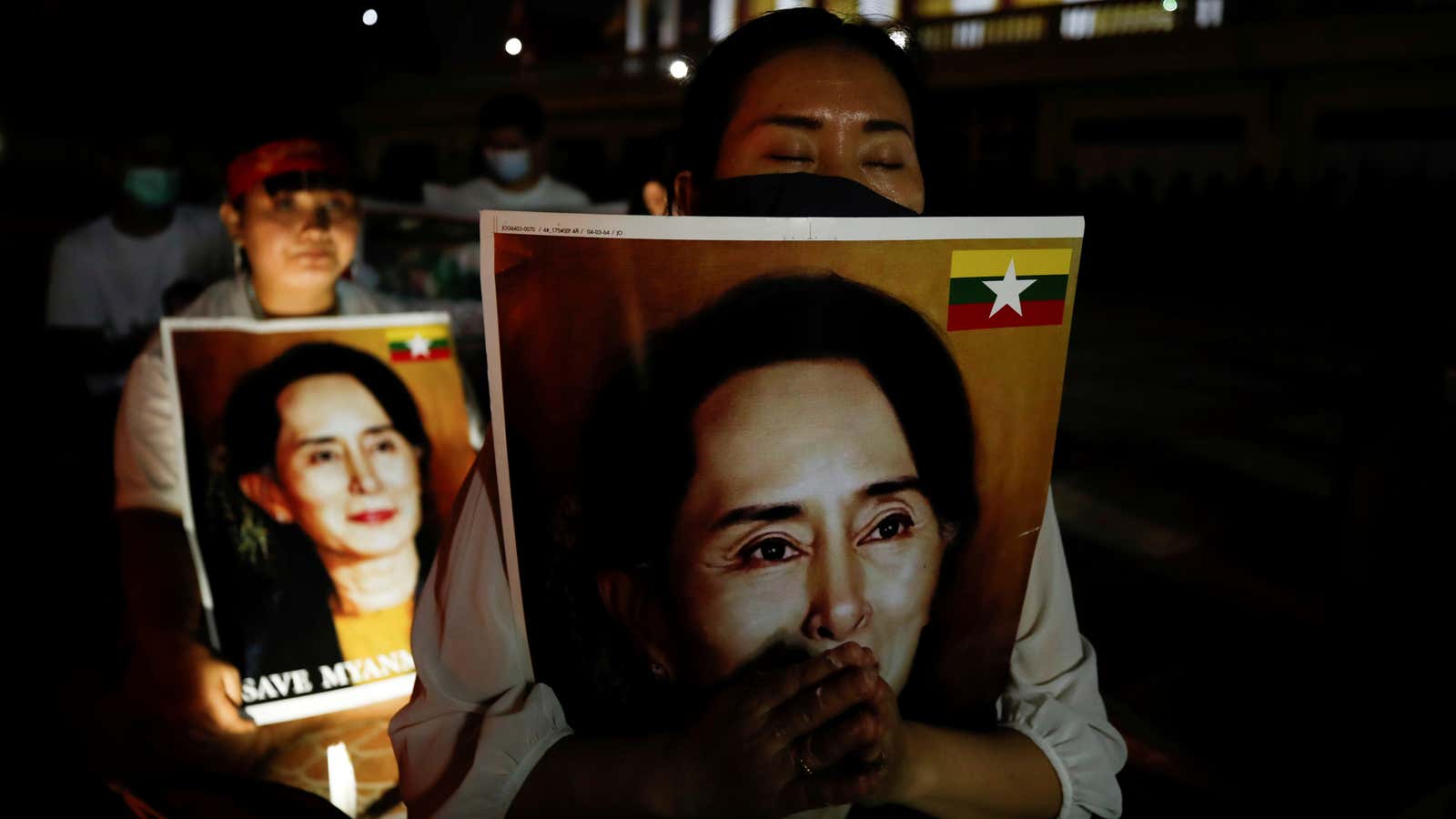 Protesters in Bangkok holding pictures of ousted Myanmar leader Aung San Suu Kyi at a candlelight vigil on March 28, 2021.