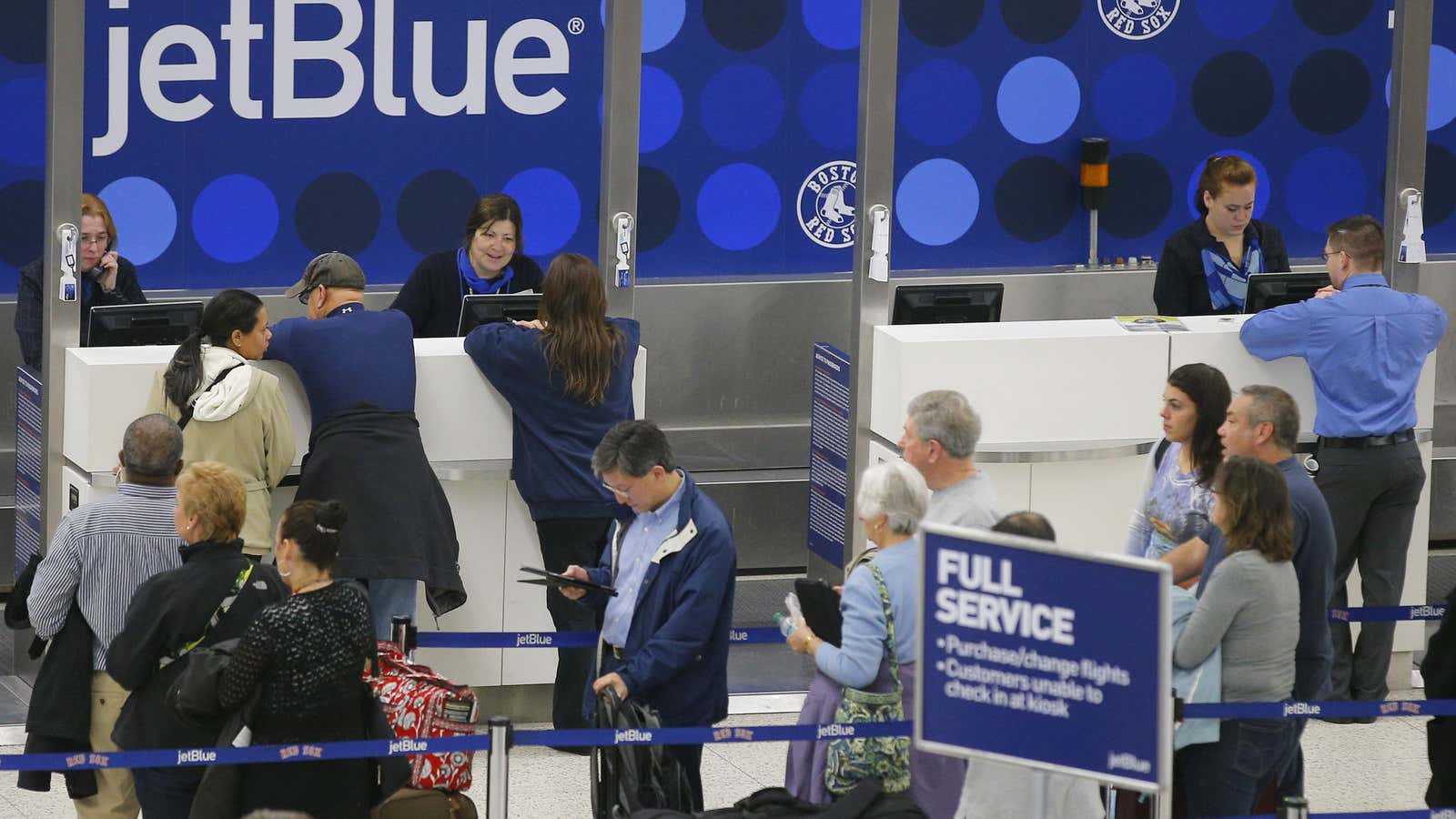 Passengers wait in line at the JetBlue ticket counter at Logan International Airport in Boston, Massachusetts January 6, 2014.