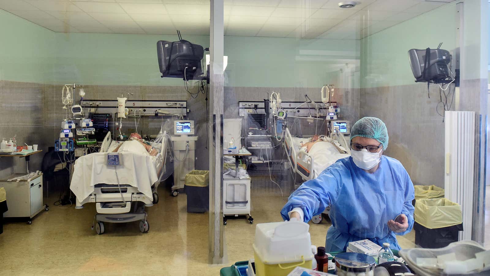 A medical worker wearing a protective mask and suit treats patients suffering from coronavirus disease (COVID-19) in an intensive care unit at the Oglio Po…
