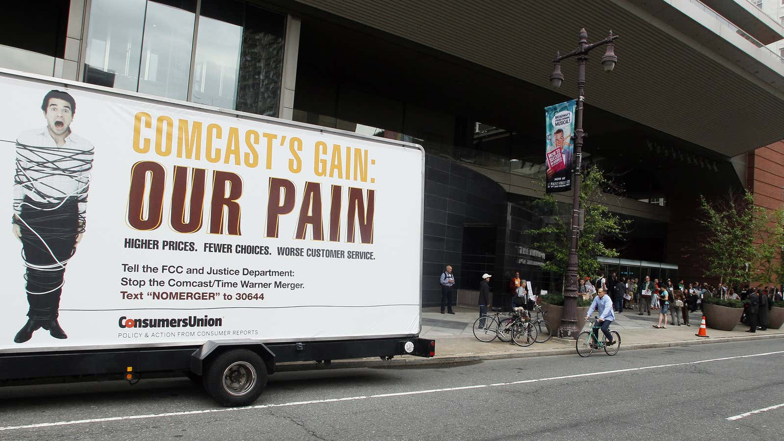 A truck bearing a message is parked near a group of local residents and consumers organizations opposing Comcast’s proposed merger with Time Warner Cable, as…