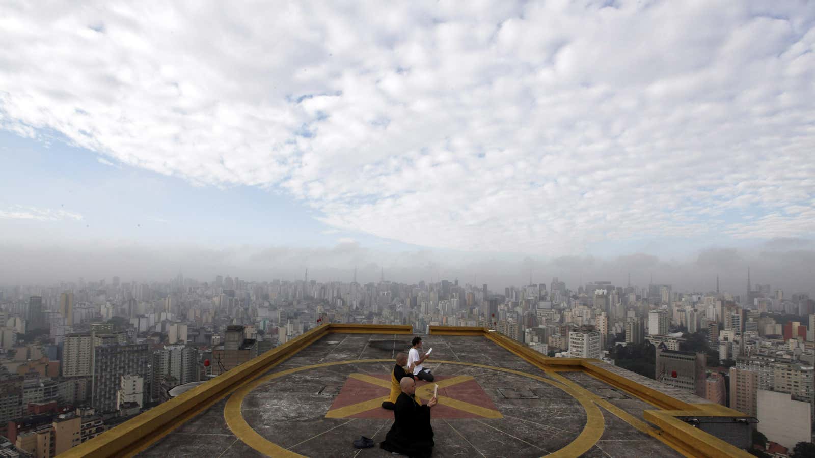 Buddhist monks Seigen, Jisho and Costa meditate on the helipad of Copan building in downtown Sao Paulo.
