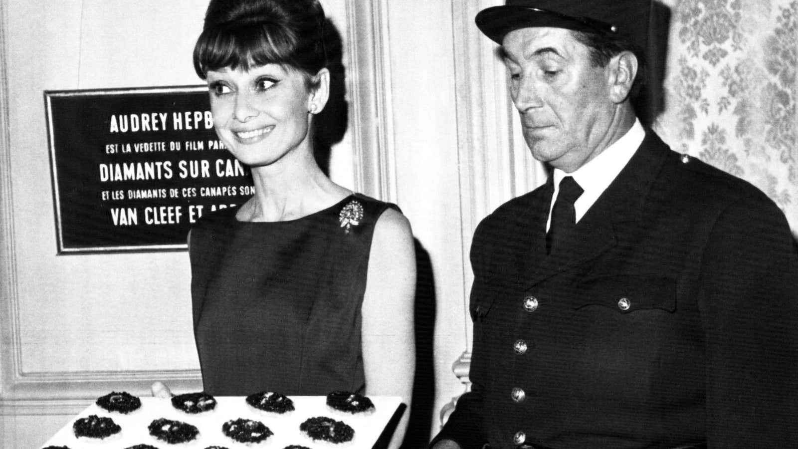 Audrey Hepburn presents $600,000 worth of diamonds on caviar sandwiches during a cocktail party at the Plaza Athenee Hotel in Paris, Jan. 12, 1962.