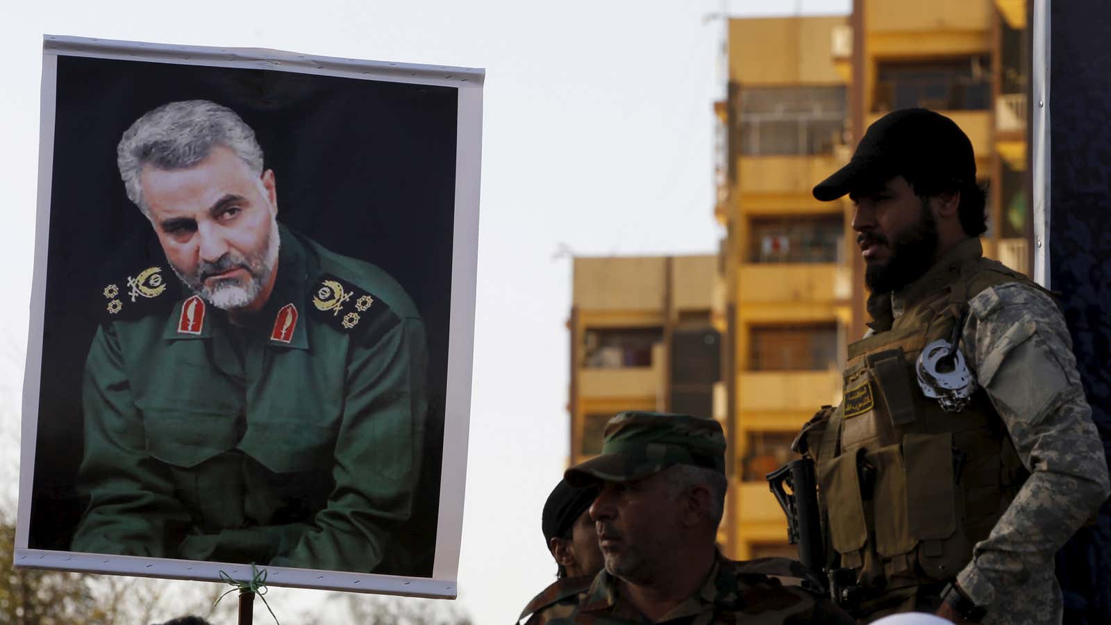 Soldiers hold a portrait of Iranian commander Qasem Soleimani.