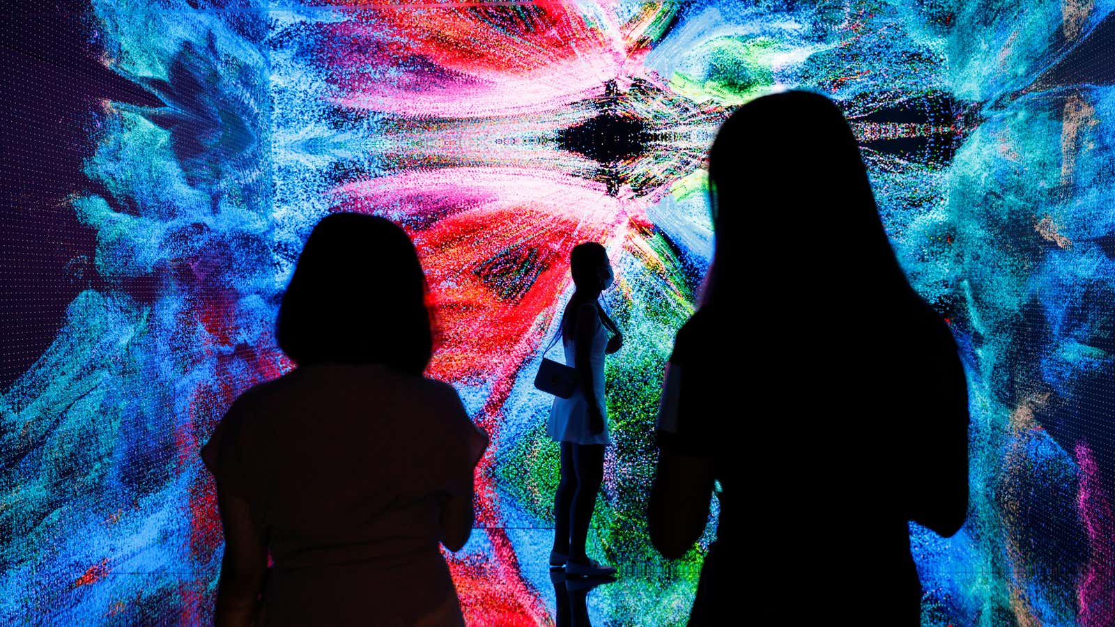 Visitors are pictured in front of an immersive art installation titled “Machine Hallucinations – Space: Metaverse” by media artist Refik Anadol, which will be converted…