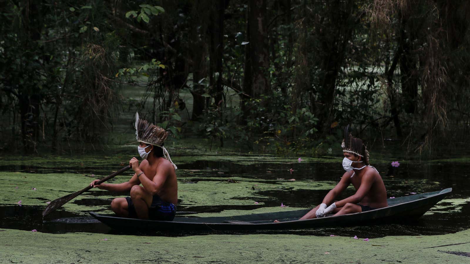 Sateré-Mawé indigenous men wearing face masks navigate the Ariau River at the Sahu-Ape community in Brazil&#39;s Amazonas State, home to most of the country&#39;s indigenous people, on May 5, 2020.