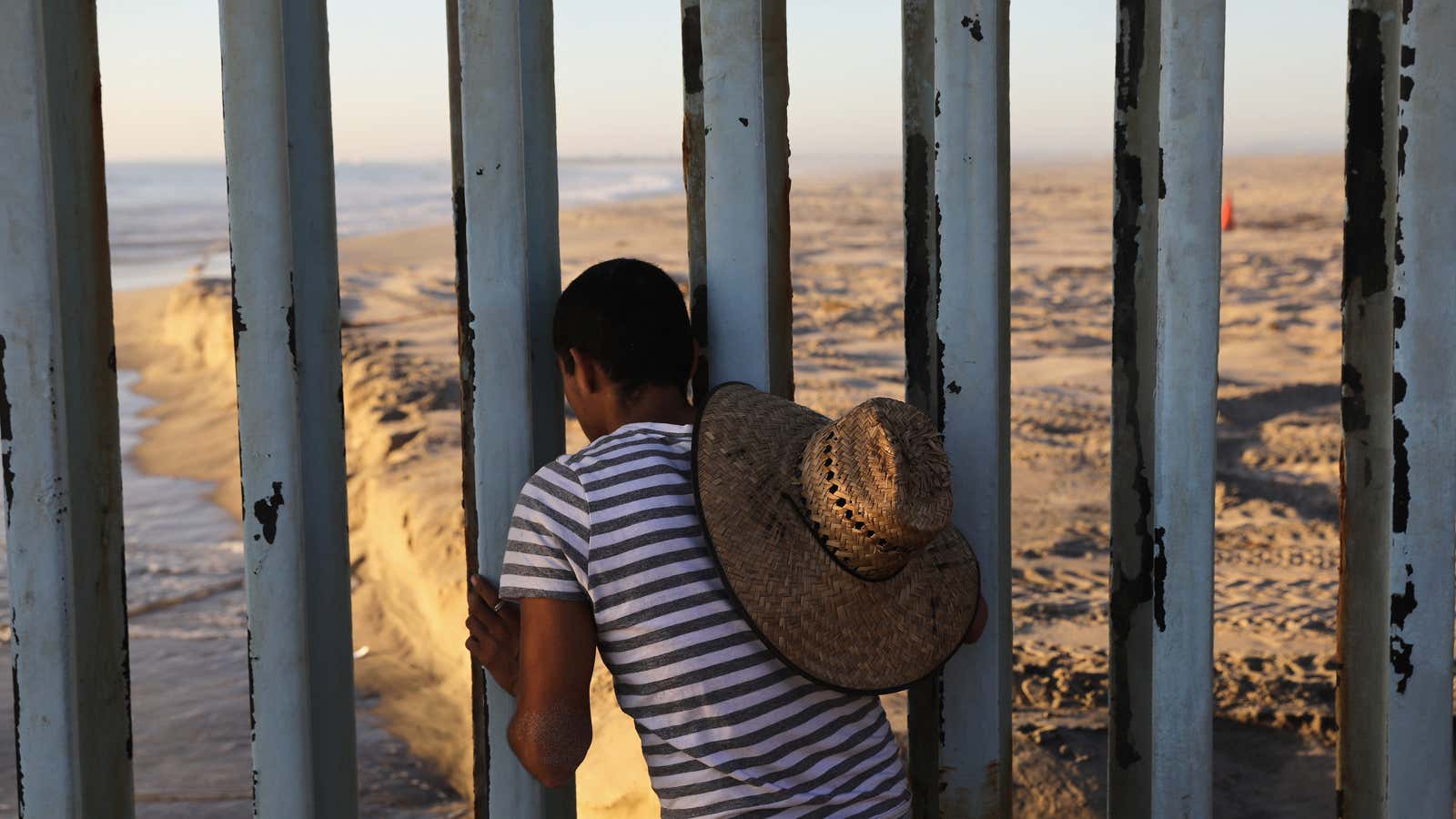 A man looks through the U.S.-Mexico border fence into the United States on September 25, 2016 in Tijuana, Mexico.