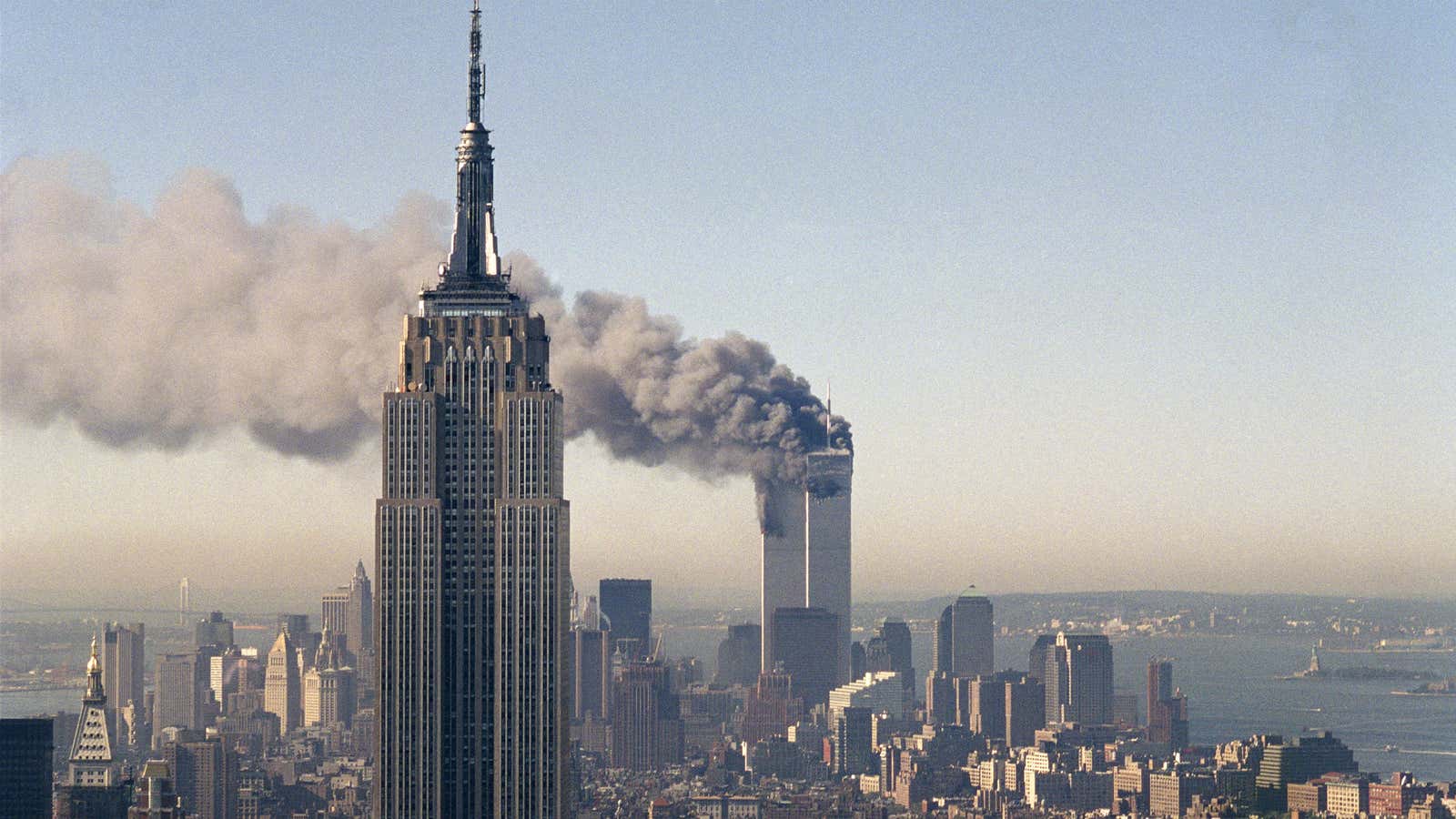 The twin towers of the World Trade Center burn behind the Empire State Building in New York.