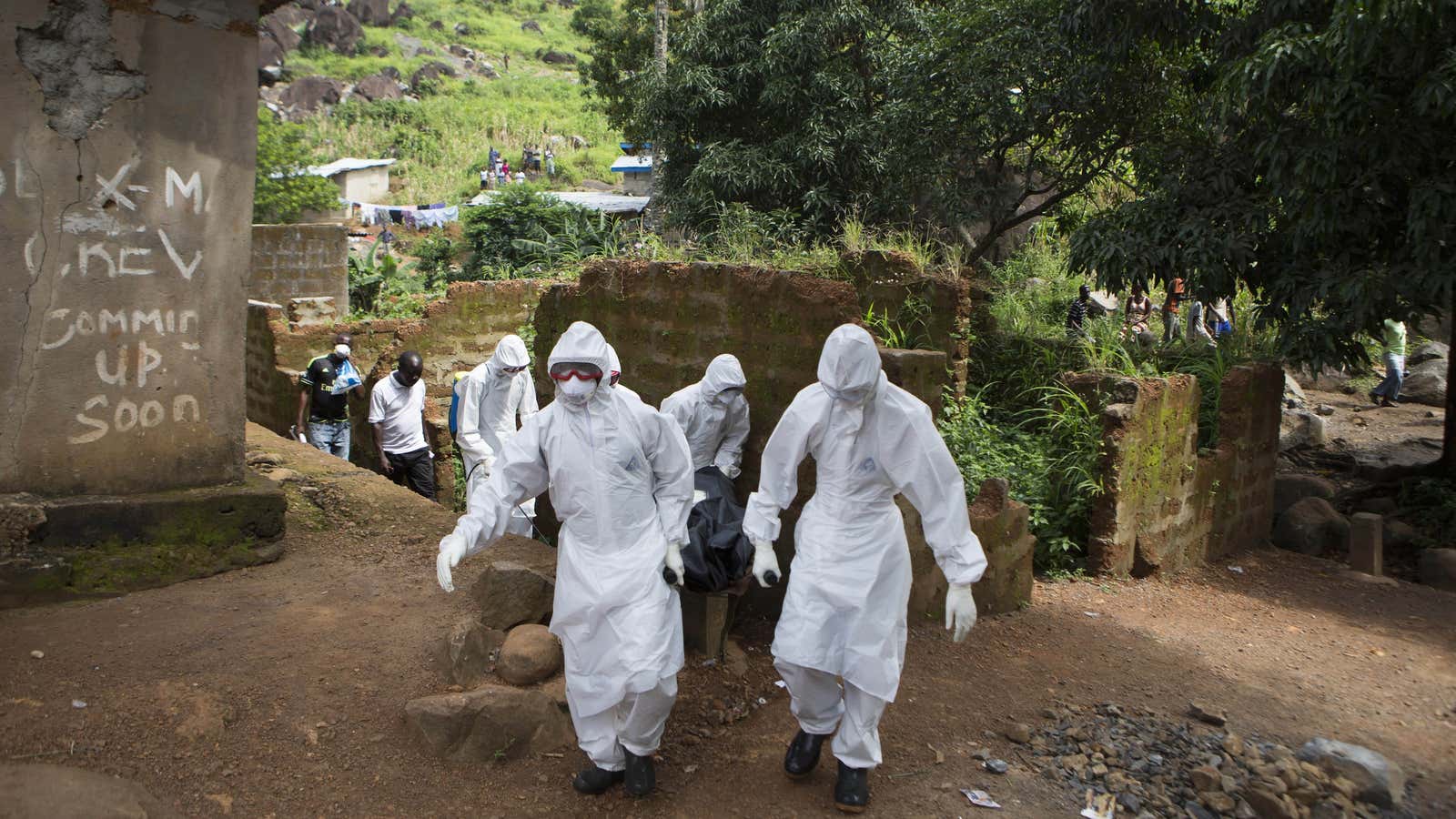 A WHO-outfitted burial team removes the body of a person suspected of succumbing to Ebola in Freetown, Sierra Leone. (Oct. 2014)