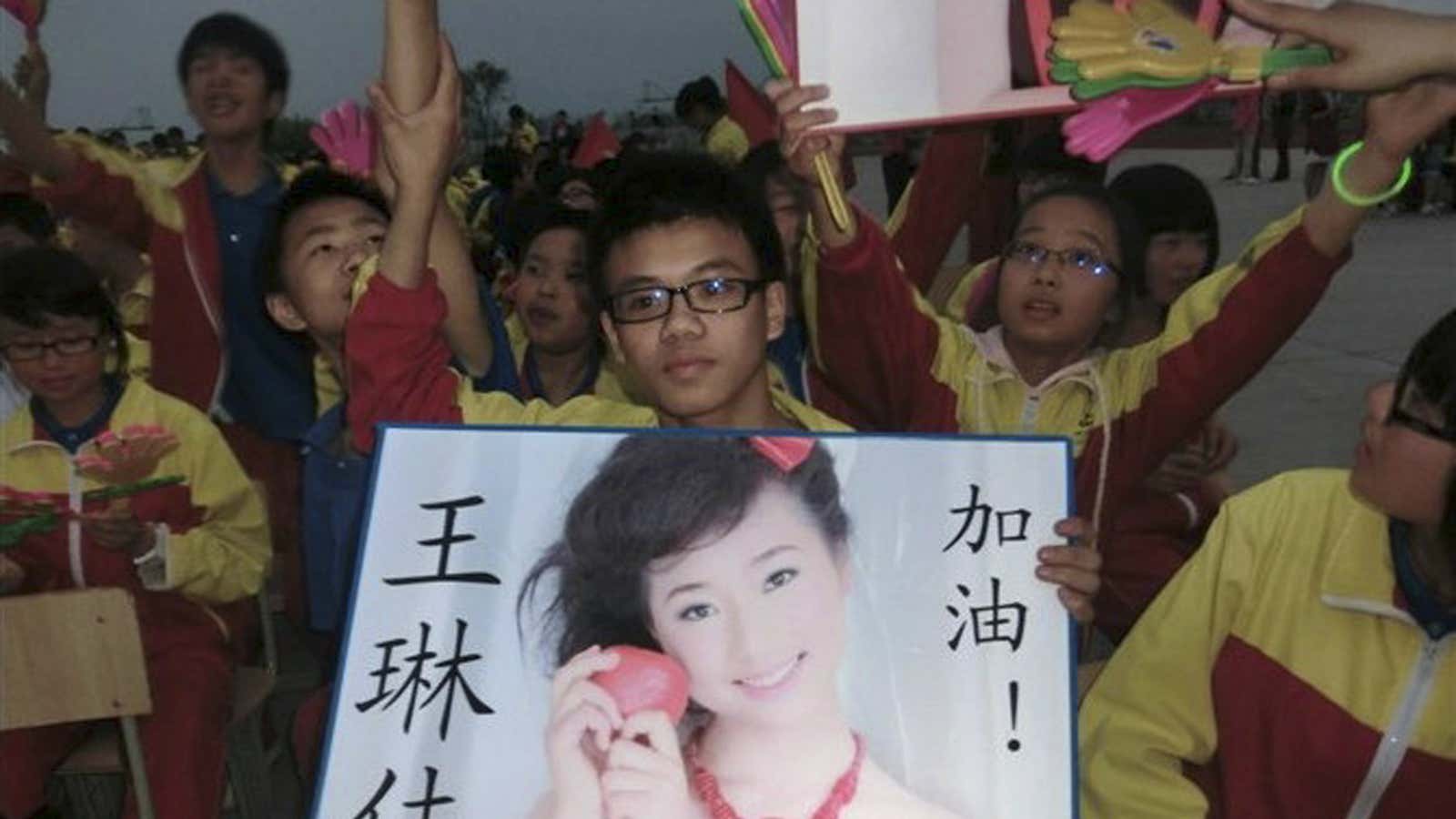 Students at a Jiangshan city school hold up a photo of their dead classmate, Wang Linjia.