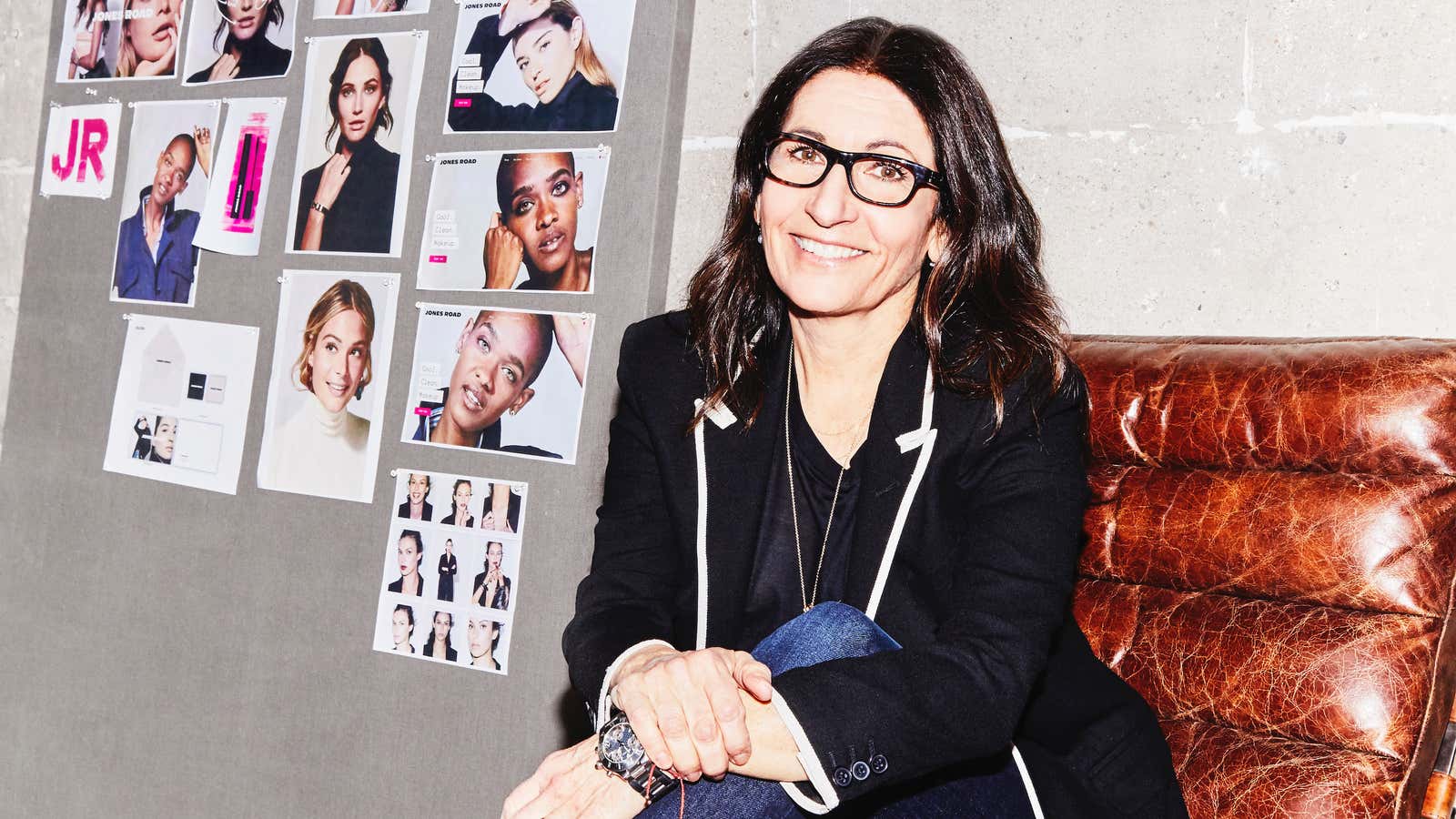 Bobbi Brown sits in a chair with beauty photos printed behind her