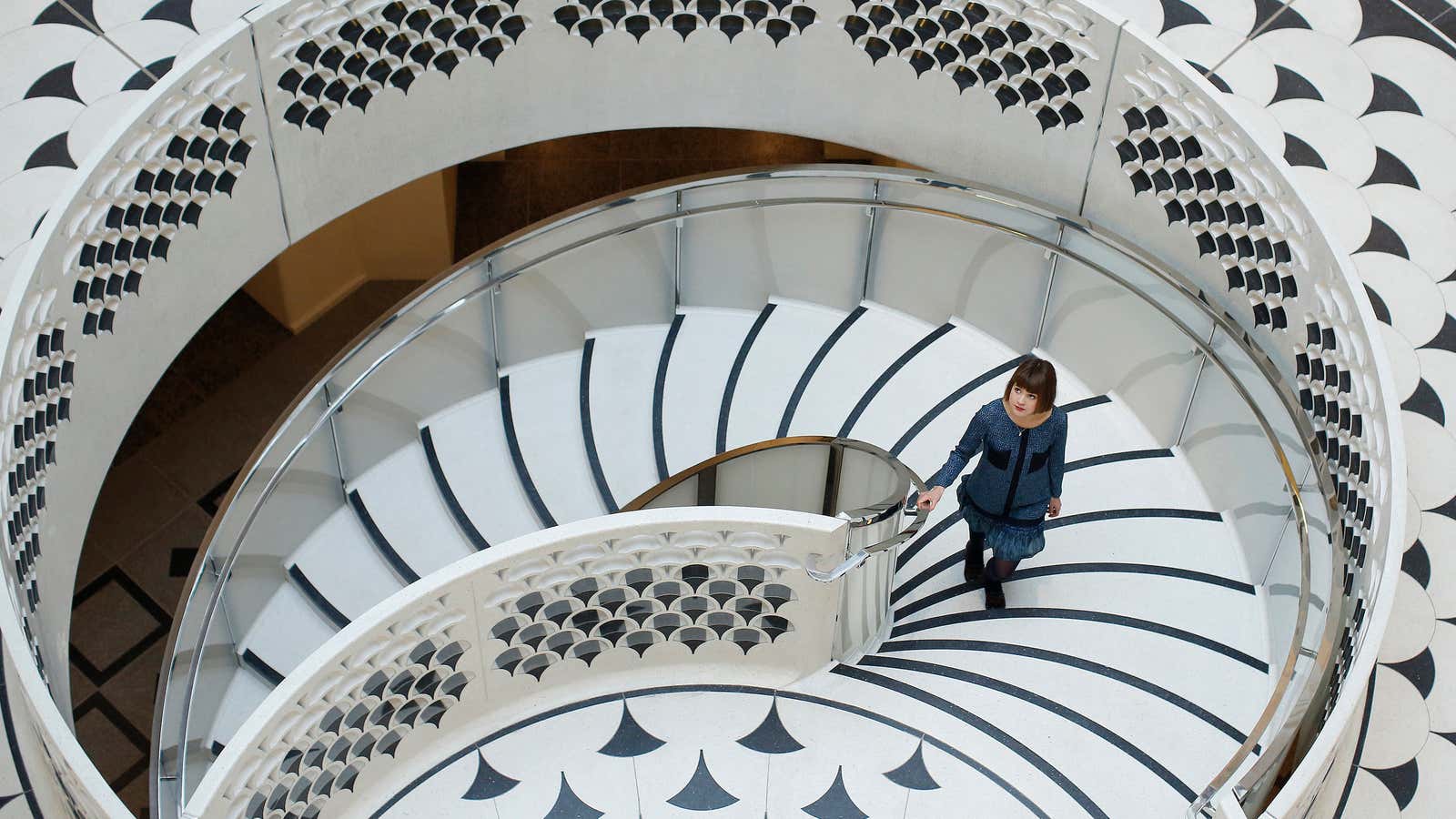 A gallery assistant poses for photographs on the new spiral staircase at Tate Britain in central London November 18, 2013. The 45 million pounds ($72.4…