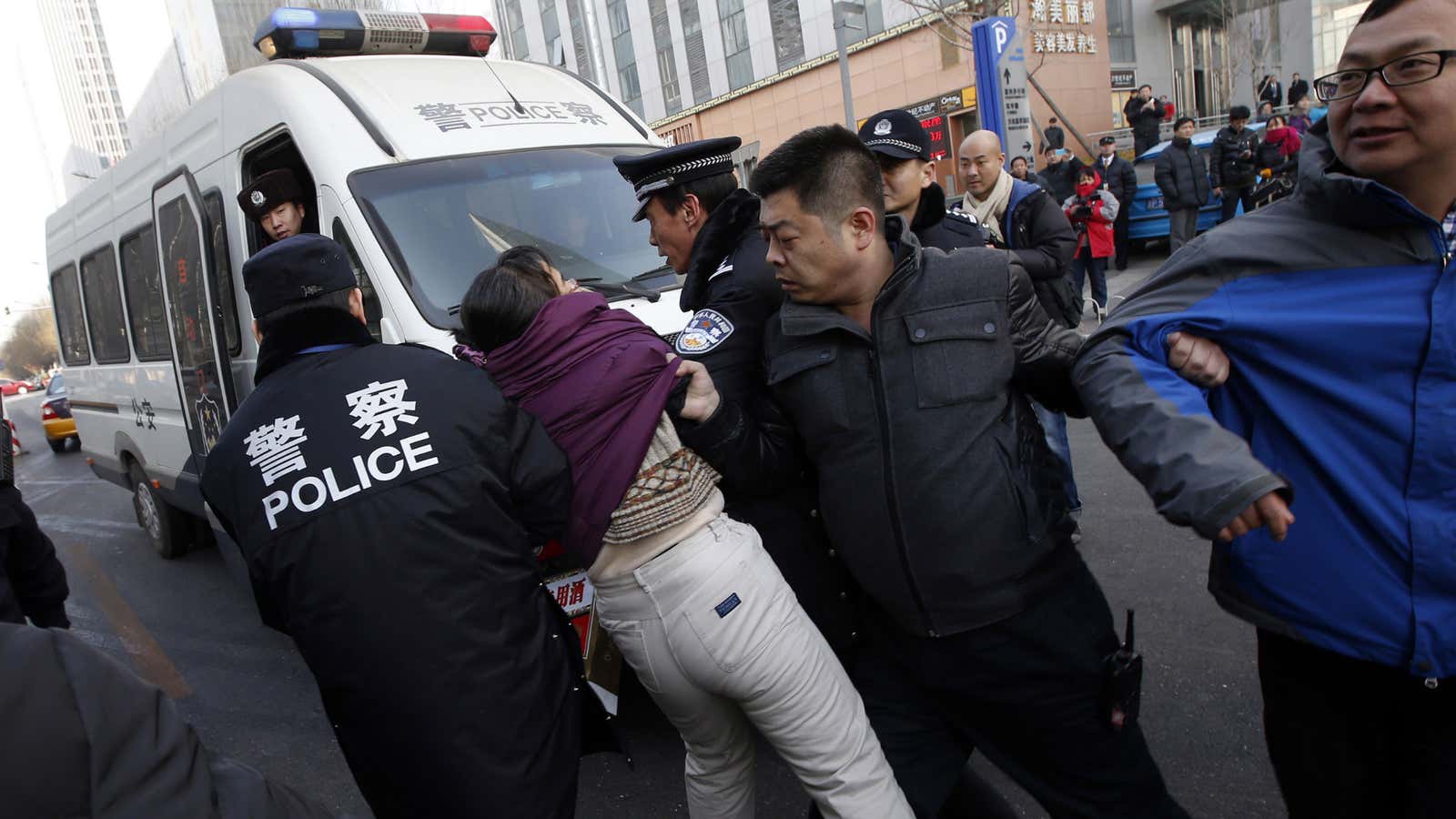 Police haul away a supporter of Xu Zhiyong in front of the Beijing courthouse where he stood trial today.