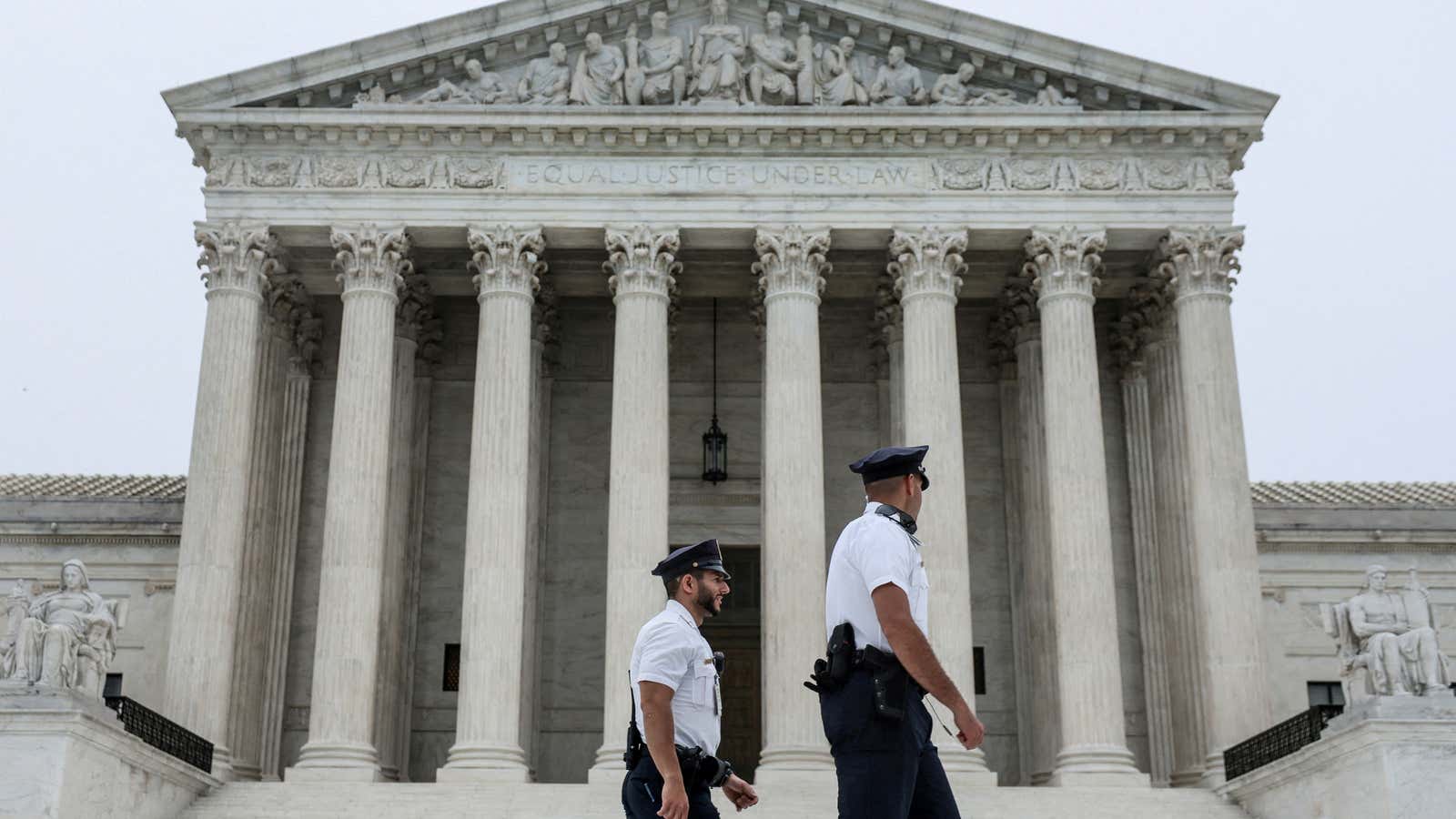 Police officers walk outside the U.S. Supreme Court in Washington, U.S., May 3, 2022.