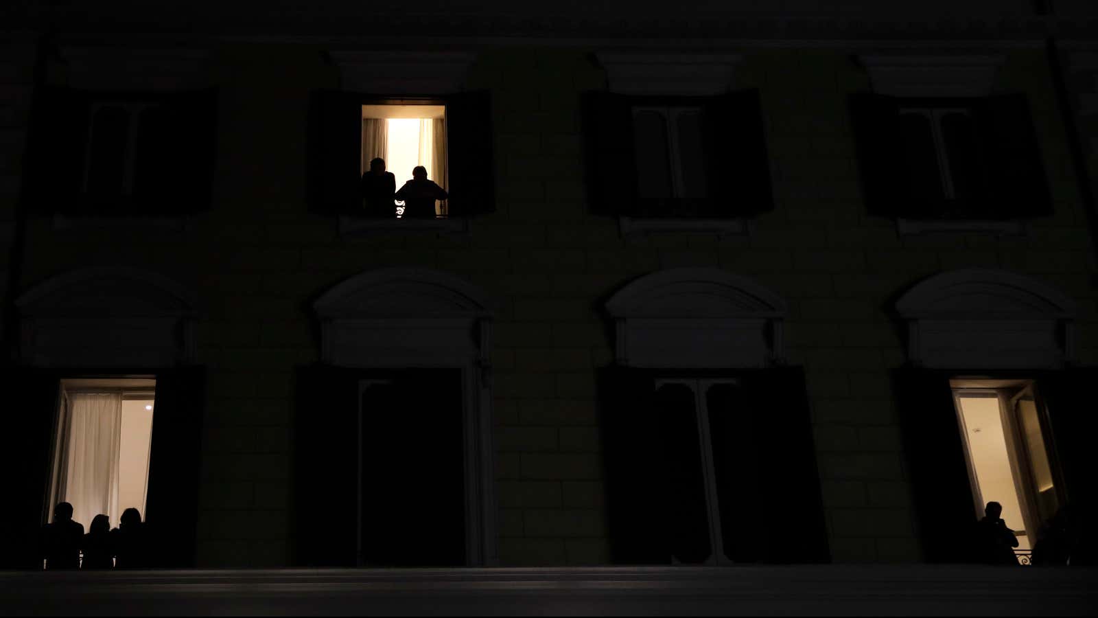 People peer out windows in Rome.