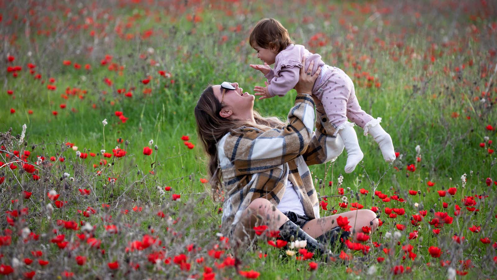 A woman plays with a child in an anemones field near Kibbutz Beeri in southern Israel, February 8, 2021.