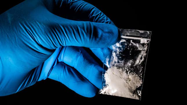 gloved hand holding a packet of fentanyl