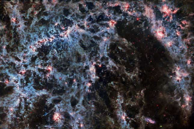 En esta imagen de la galaxia espiral barrada NGC 5068 tomada por el instrumento MIRI del telescopio espacial James Webb, se puede ver claramente la estructura de la galaxia espiral y las burbujas brillantes de gas que contienen cúmulos estelares recién formados. Se pueden ver algunos asteriodes en la imagen (esos pequeños puntos azules verdes y rojos). Los asteroides aparecen en imágenes astronómicas como estas porque están mucho más cerca del telescopio que el resto de objetos distantes.